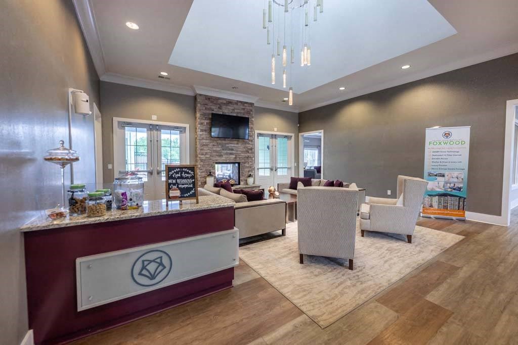 A reception area with a red counter and a white chair at Foxwood Apartments, North Carolina, 27616