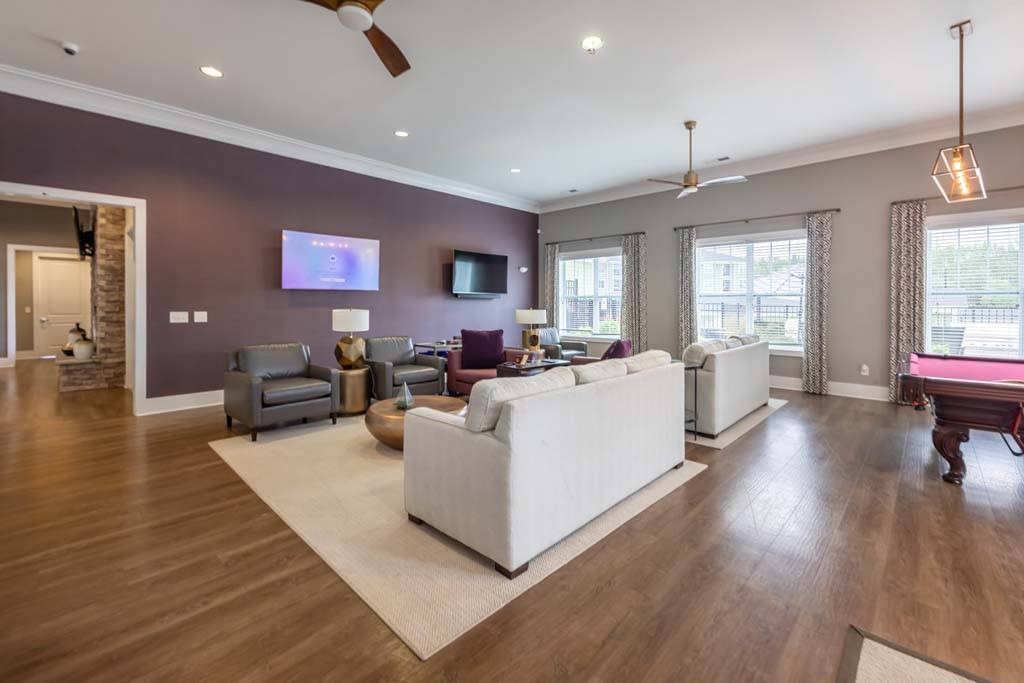 A living room with a white couch and a television on the wall at Foxwood Apartments, Raleigh-Durham, NC