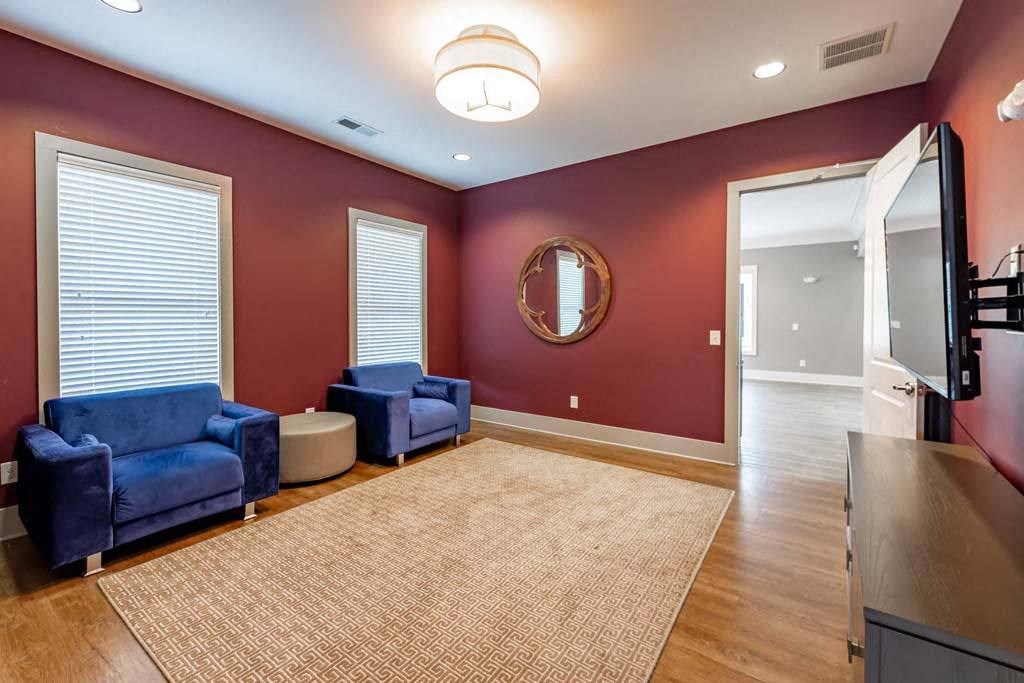 A living room with a blue couch and a round mirror on the wall at Foxwood Apartments, Raleigh-Durham, 27616