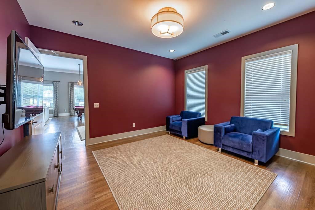 A living room with a red wall and a beige rug at Foxwood Apartments, Raleigh-Durham, NC, 27616