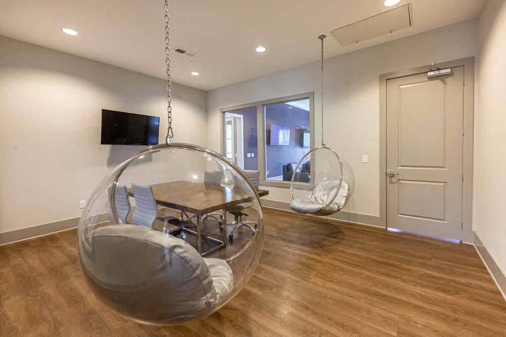 A room with a wooden floor and a hanging chair at Foxwood Apartments, North Carolina