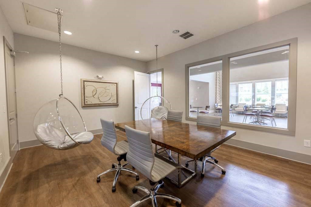 A room with a wooden table and white chairs at Foxwood Apartments, Raleigh-Durham, North Carolina