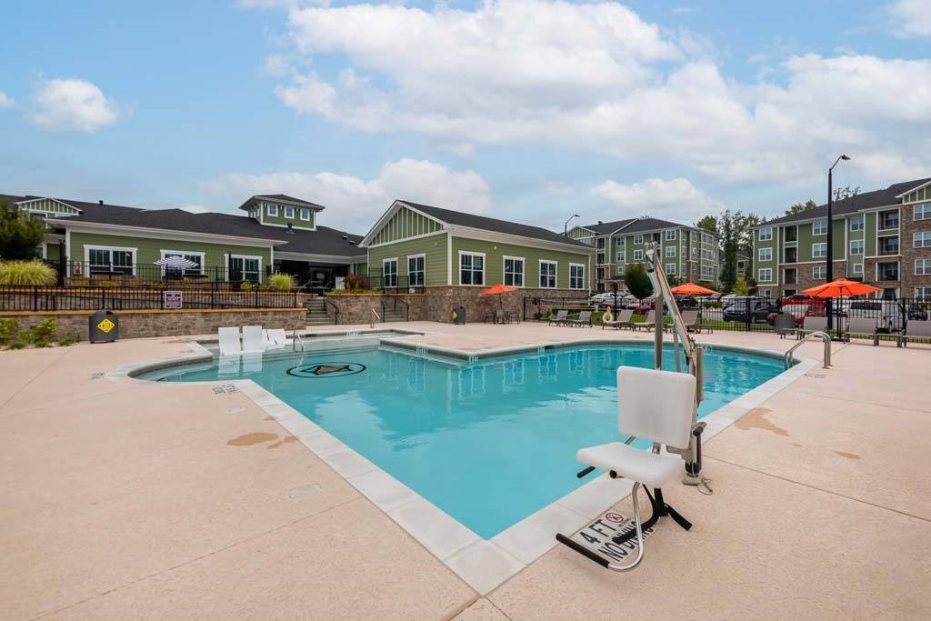 A swimming pool with a slide and a sun lounger at Foxwood Apartments, Raleigh-Durham, NC