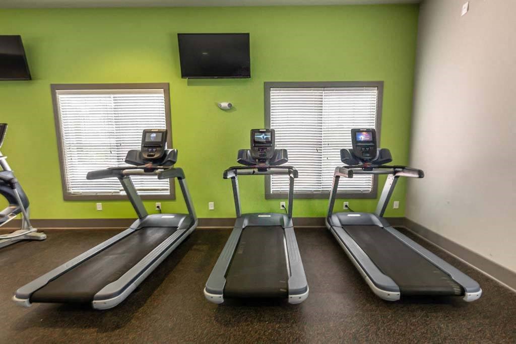 Three treadmills are lined up in a row in a gym at Foxwood Apartments, Raleigh-Durham, NC, 27616
