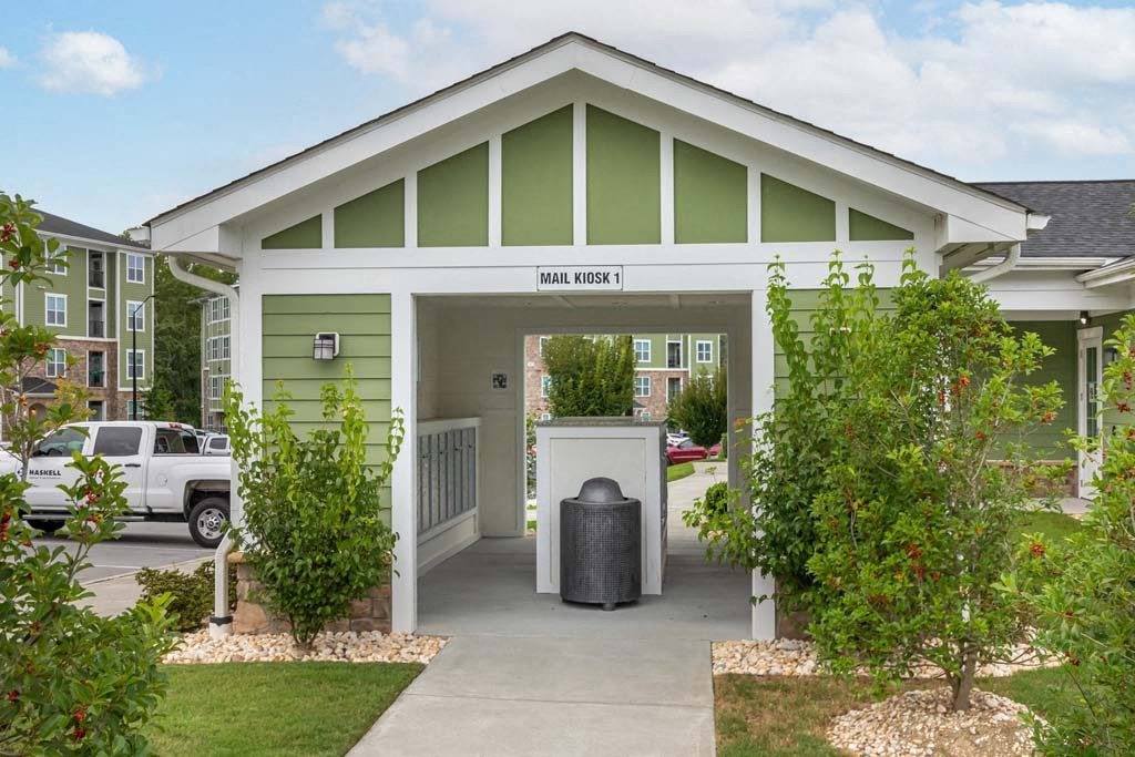 A green and white building with a sign at Foxwood Apartments, North Carolina
