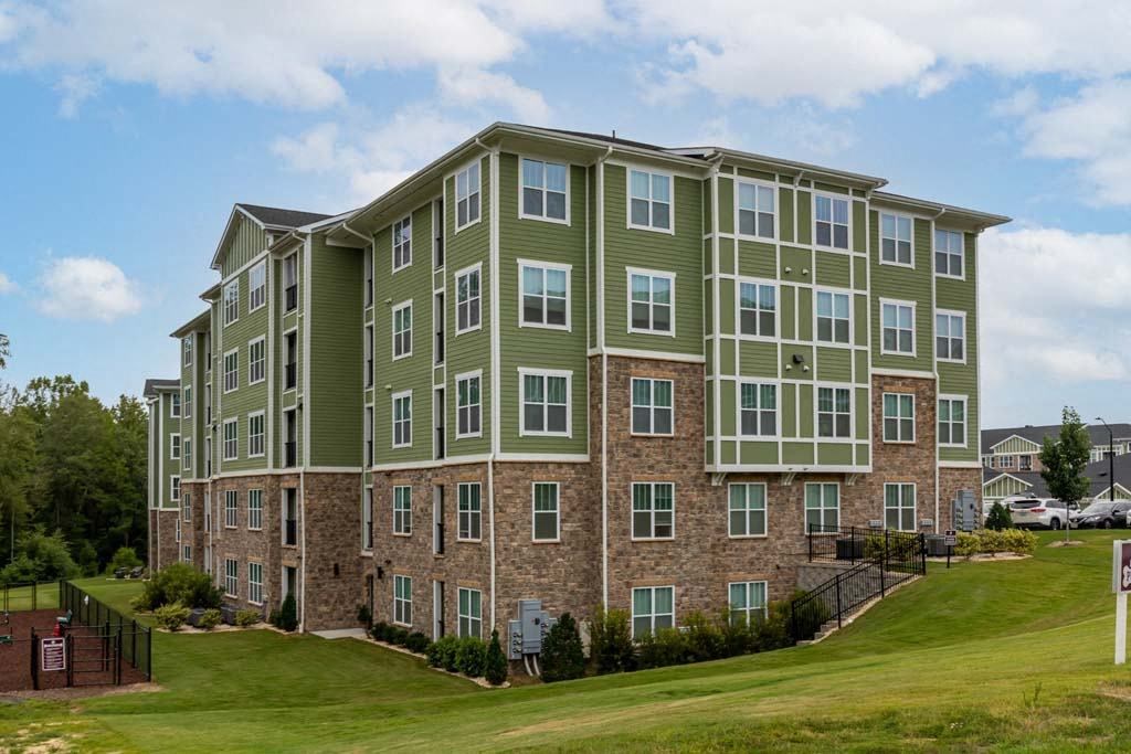 A large apartment building with a green and brown exterior at Foxwood Apartments, Raleigh-Durham, NC, 27616