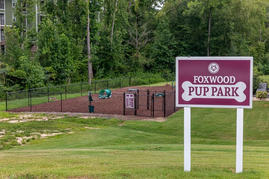 A sign for Foxwood Puppark stands in front of a fenced area at Foxwood Apartments, Raleigh-Durham, 27616