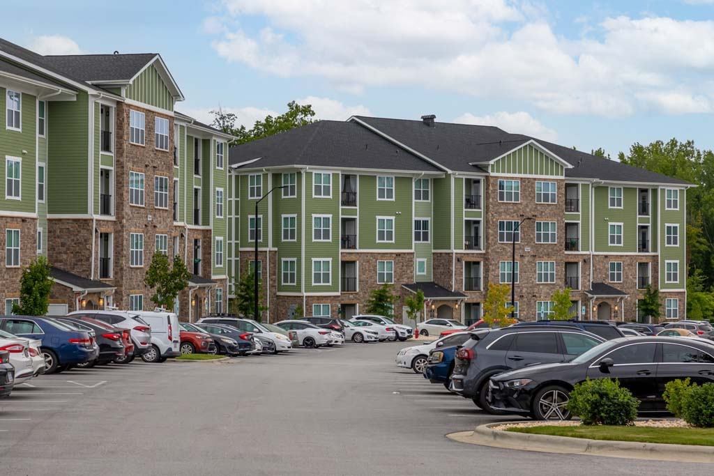 A parking lot with cars and apartment buildings in the background at Foxwood Apartments, Raleigh-Durham, 27616