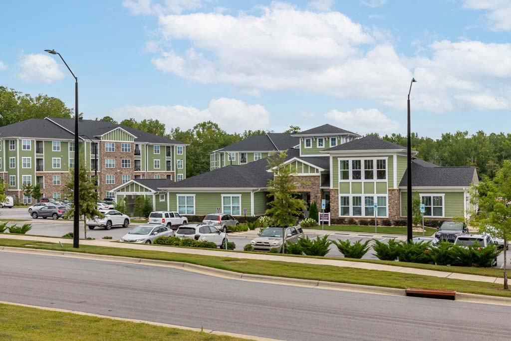 Apartment complex with green and brown buildings and cars parked in front at Foxwood Apartments, Raleigh-Durham, North Carolina