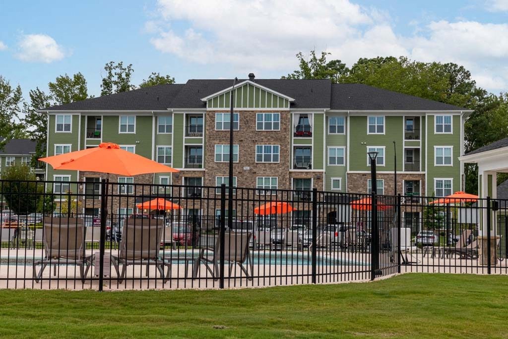 A large building with a pool in front of it at Foxwood Apartments, Raleigh-Durham, NC