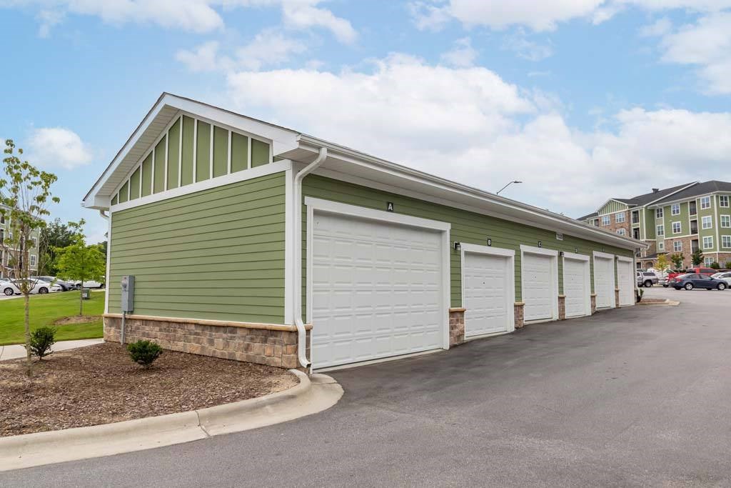 A green building with a white garage door at Foxwood Apartments, Raleigh-Durham