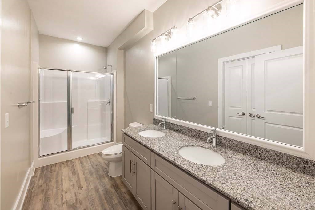 A bathroom with a toilet, sink, and mirror at Foxwood Apartments, Raleigh-Durham, 27616