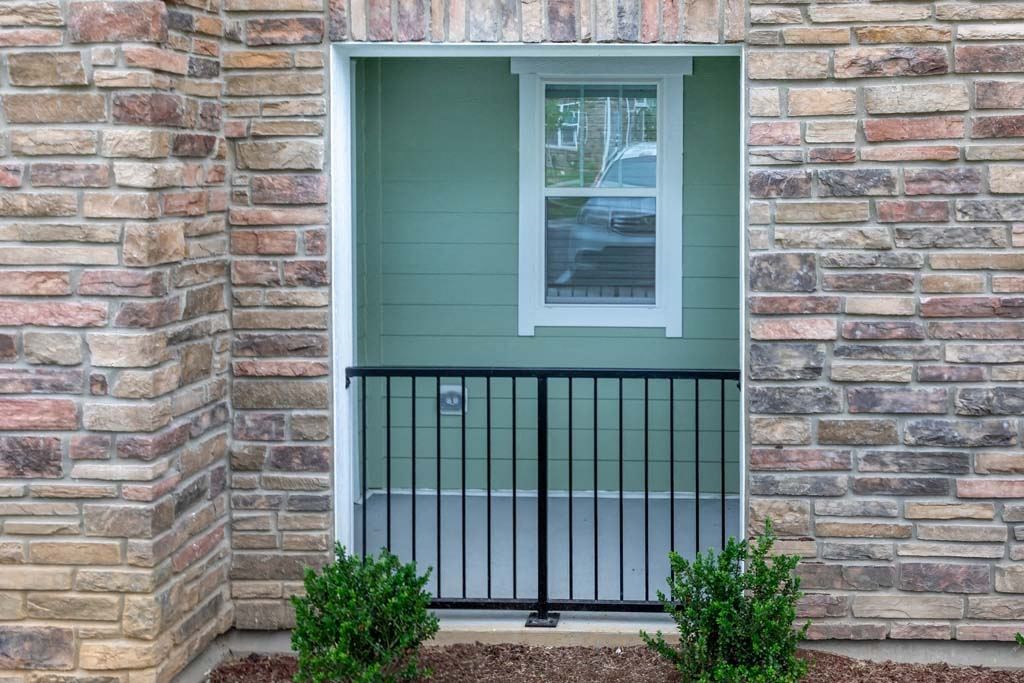 A window with a black iron railing and a green wall at Foxwood Apartments, North Carolina, 27616