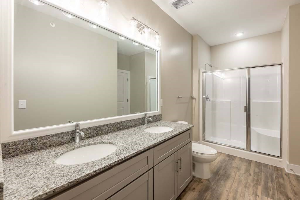 A bathroom with a granite countertop and a walk-in shower at Foxwood Apartments, Raleigh-Durham