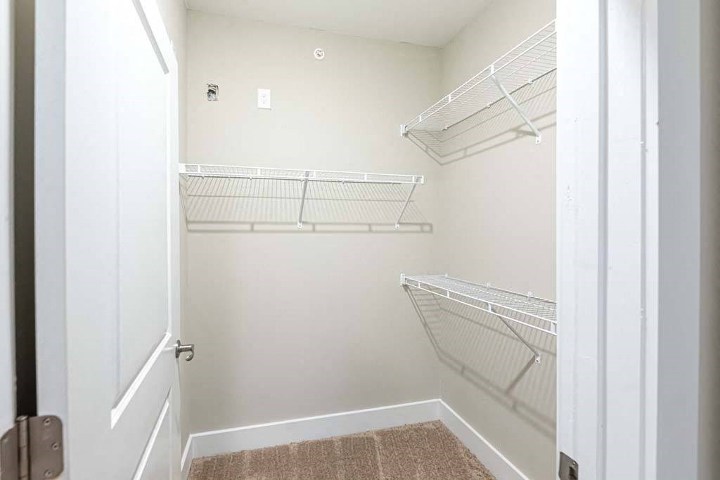 A white closet with a brown rug on the floor at Foxwood Apartments, North Carolina, 27616