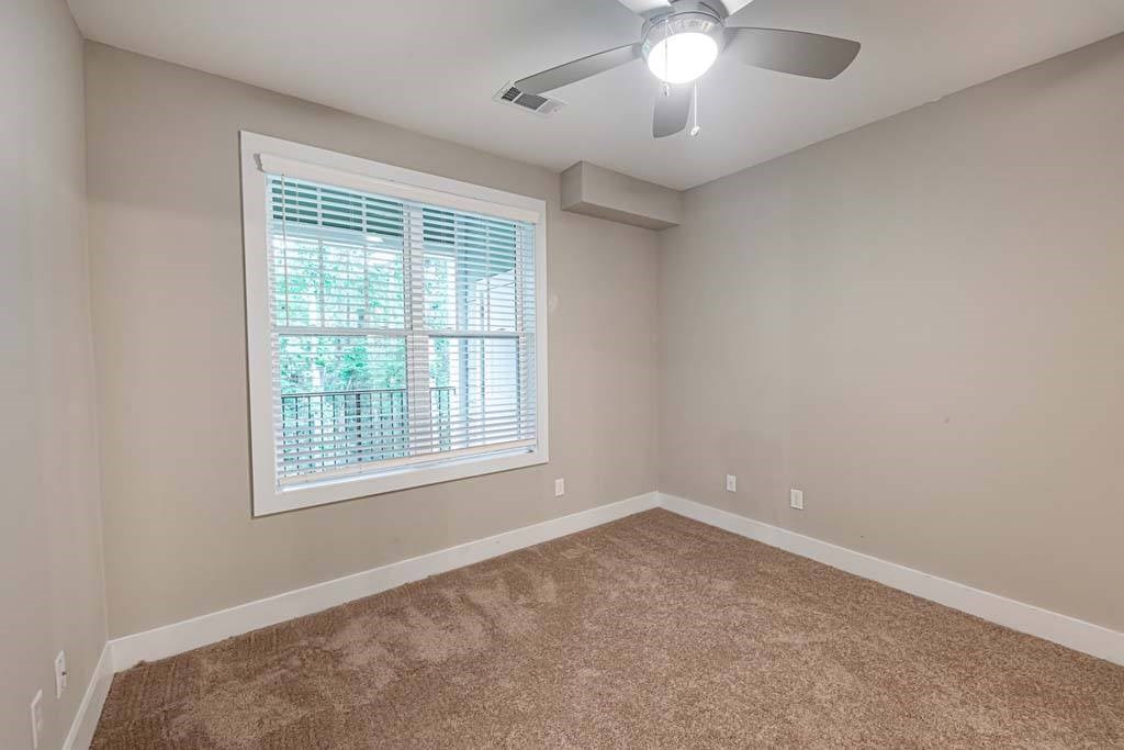A room with a ceiling fan and a window with blinds at Foxwood Apartments, Raleigh-Durham, North Carolina