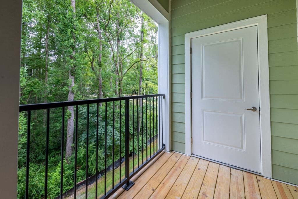 A white door is on the right side of a balcony with a black railing at Foxwood Apartments, Raleigh-Durham, NC