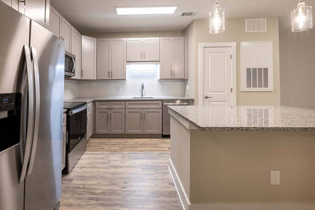 A kitchen with a refrigerator, microwave, and cabinets at Foxwood Apartments, North Carolina