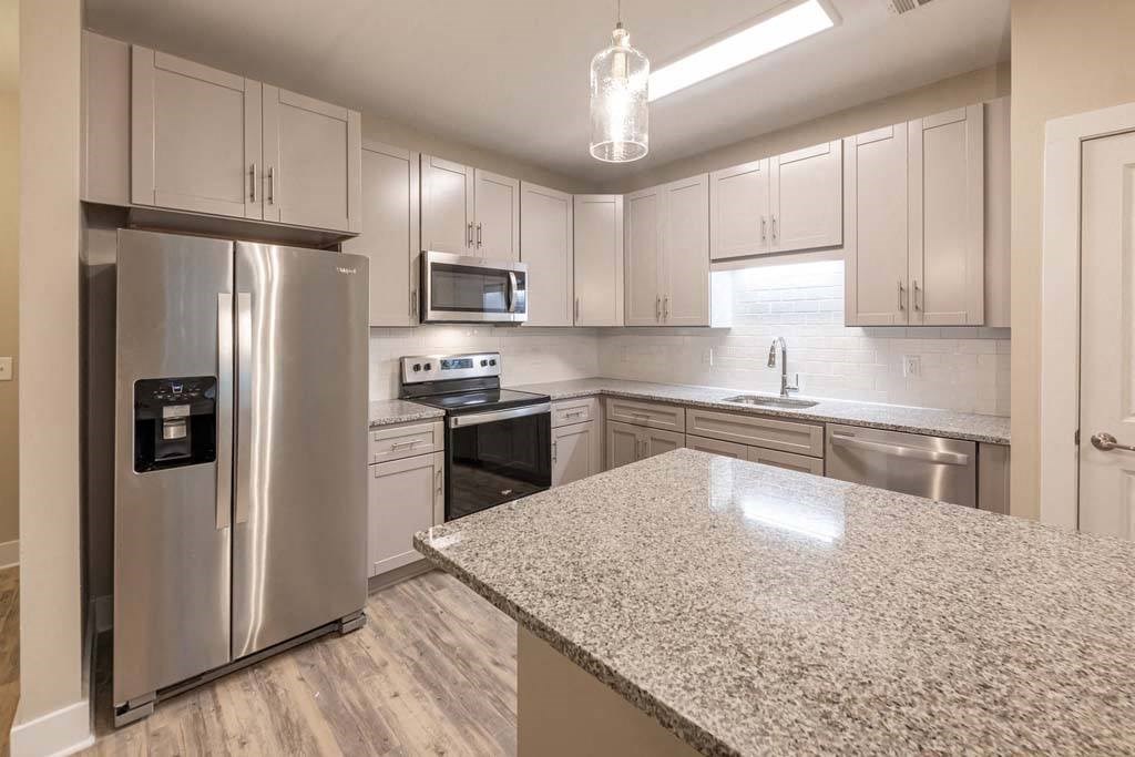 A kitchen with a granite countertop and stainless steel appliances at Foxwood Apartments, North Carolina