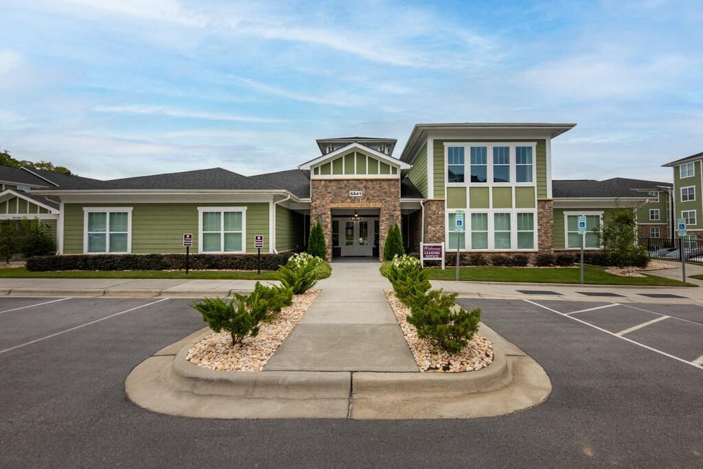 A building with a grey roof and a sign in front of it at Foxwood Apartments, Raleigh-Durham, North Carolina