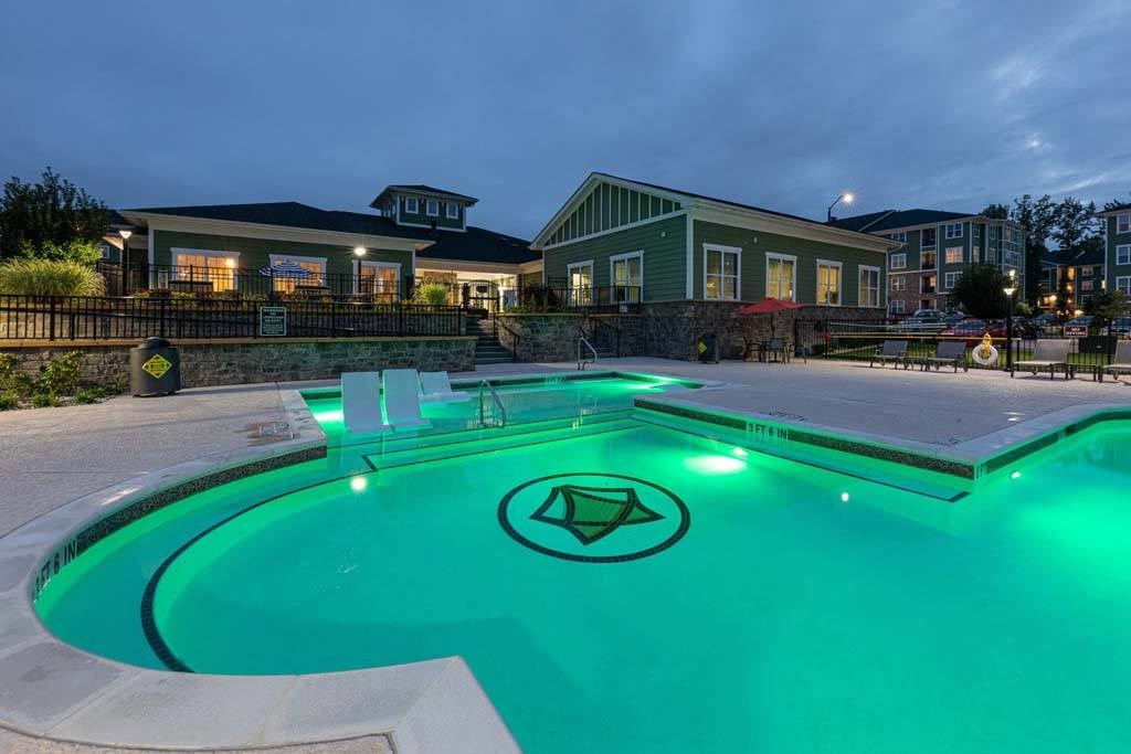 A swimming pool with a greenish tint and a logo in the middle at Foxwood Apartments, Raleigh-Durham, 27616