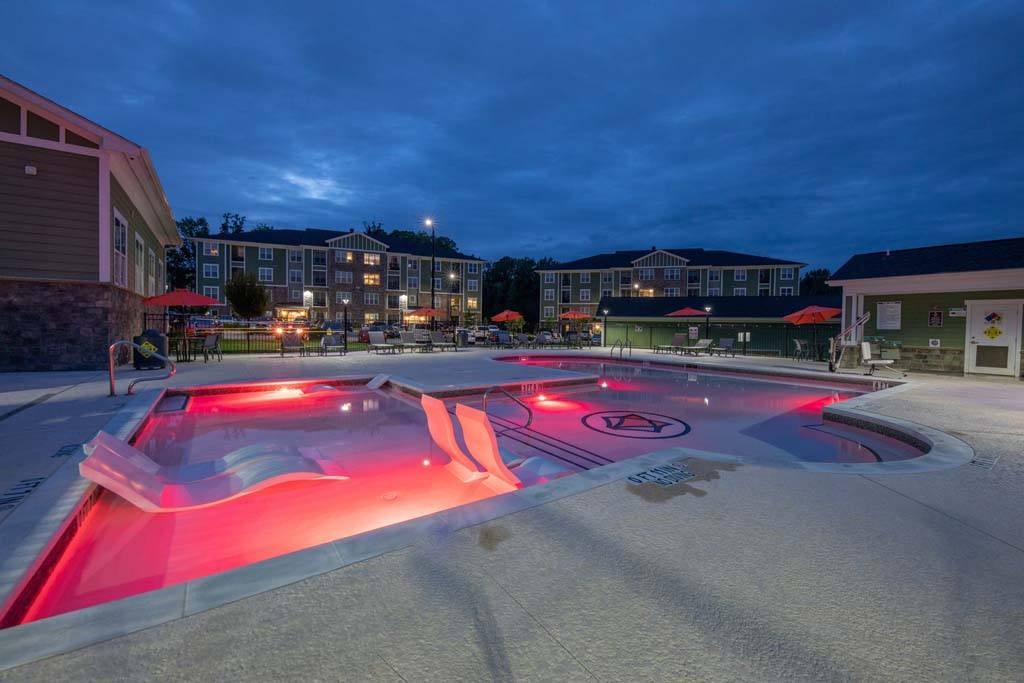 A pool lit up with red lights at night at Foxwood Apartments, North Carolina, 27616
