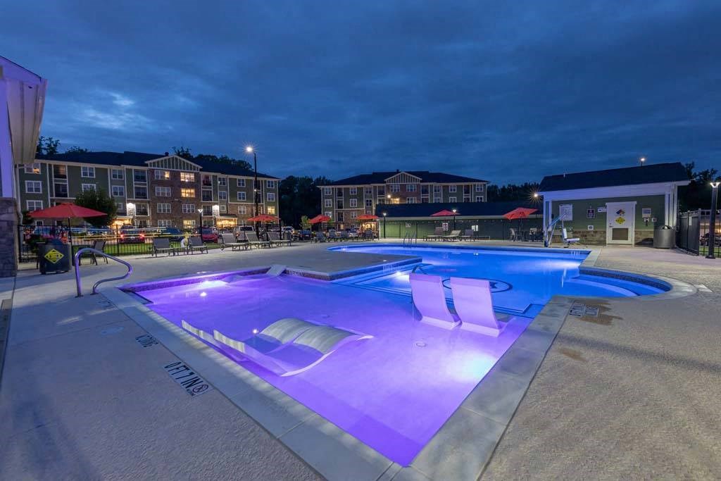 A lit up swimming pool at night. at Foxwood Apartments, Raleigh-Durham, NC, 27616