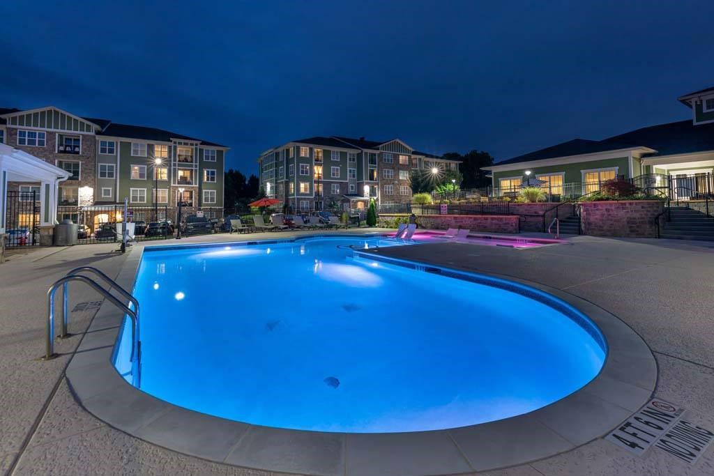 A round swimming pool in a residential area at night. at Foxwood Apartments, Raleigh-Durham, 27616