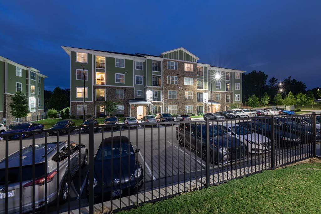A parking lot with cars and a building in the background at Foxwood Apartments, Raleigh-Durham, NC, 27616