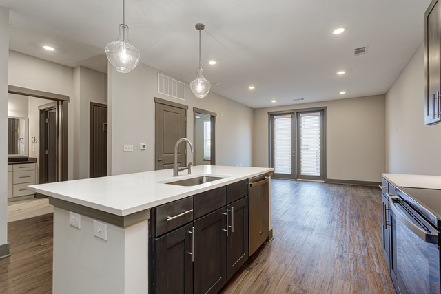 an open kitchen and living room with a large white counter top