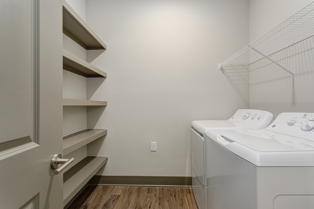 a laundry room with a washer and dryer and a closet with shelves