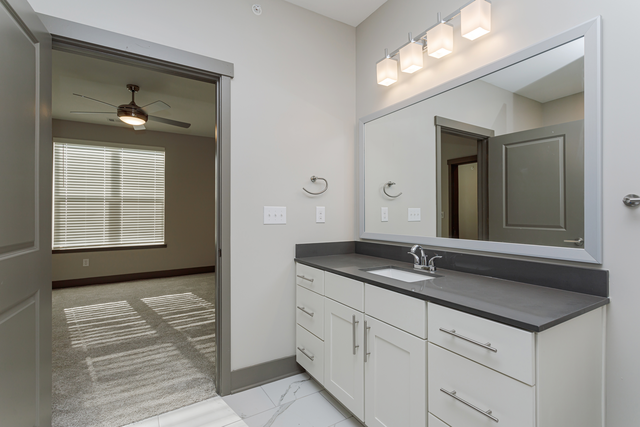 an empty bathroom with a mirror and a sink