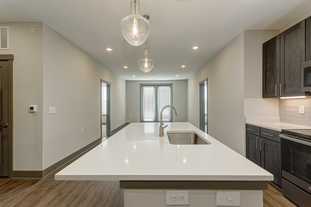 a kitchen with a large white counter top and a sink