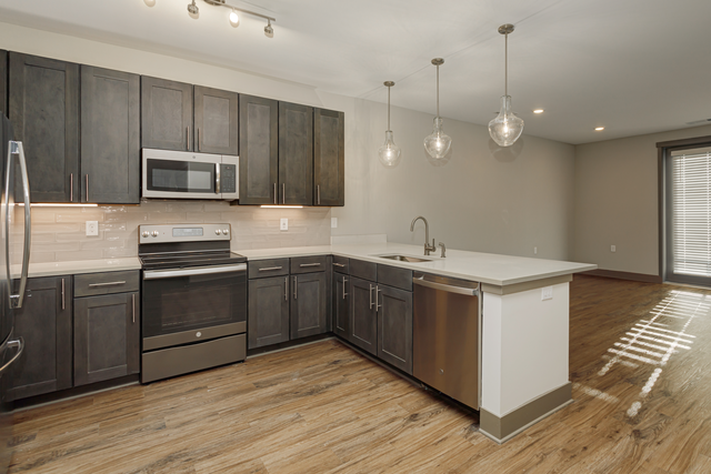 a kitchen with dark wood cabinets and a white counter top and a sink