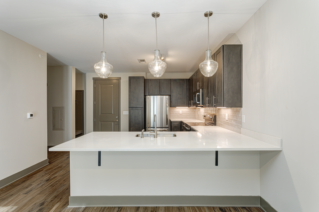 a kitchen with a large white counter top and a sink