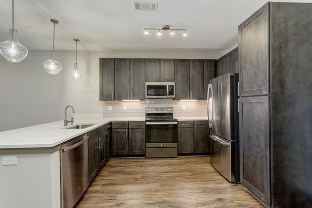 a kitchen with wooden cabinets and stainless steel appliances