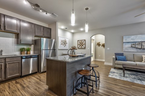 a kitchen with stainless steel appliances and a bar with stools