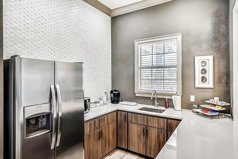 A modern kitchen with a stainless steel refrigerator and wooden cabinets.