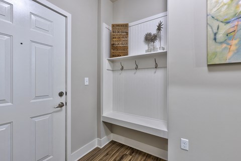 an entryway with white walls and a white door