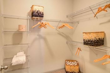 a walk in closet with metal shelves and baskets