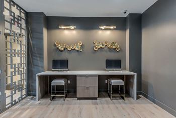 a room with two computers and three gold sculptures on the wall