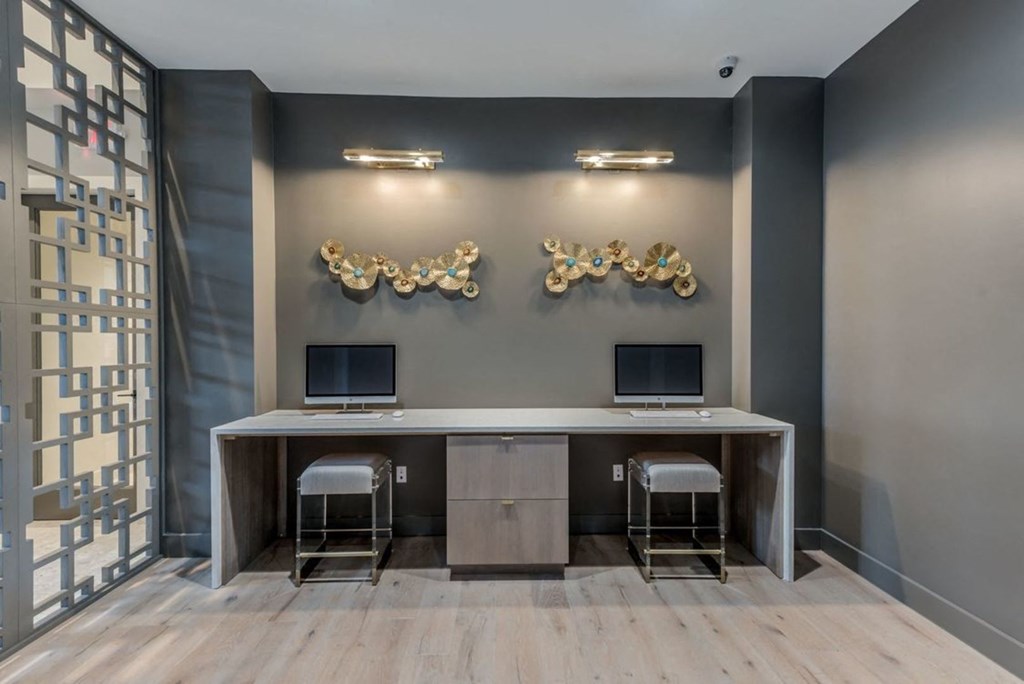 a room with two computers and three gold sculptures on the wall