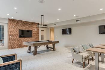 a games room with a billiards table and a flat screen tv