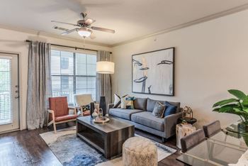 a living room with a couch coffee table and a ceiling fan