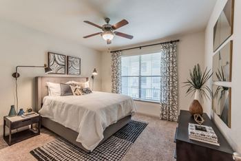 a bedroom with a large bed and a ceiling fan