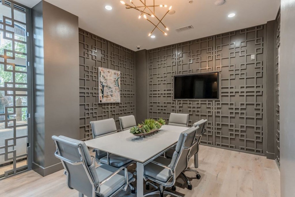 a conference room with a table and chairs and a tv on the wall