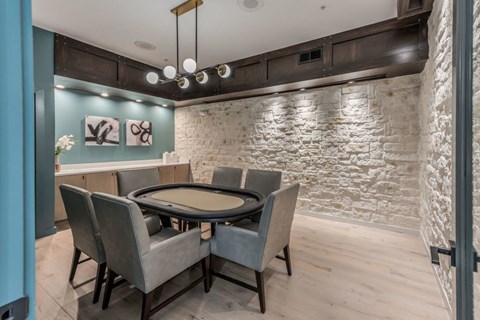 a dining room with a table and chairs in front of a brick wall