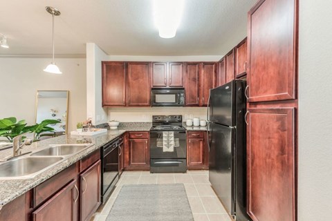 a kitchen with black appliances and wooden cabinets