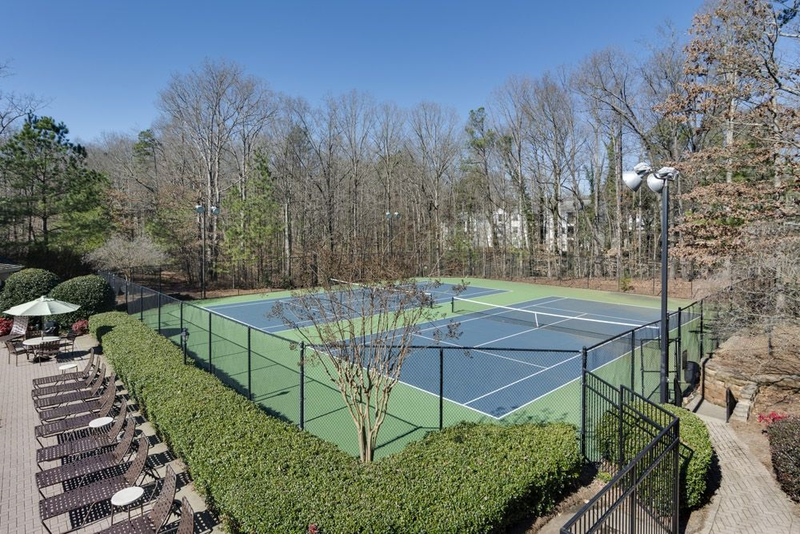 a swimming pool with chairs around it in front of a building