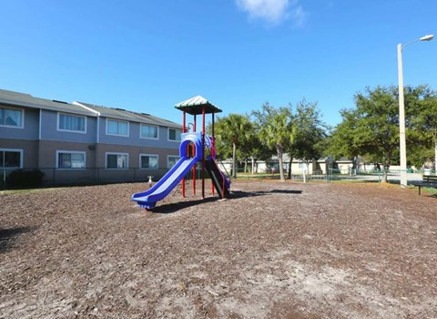 A playground with a purple slide and a white canopy.